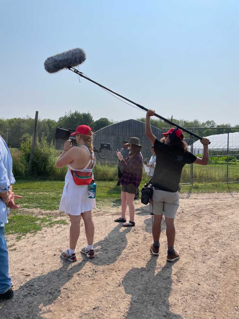 A small group of videographers filming on a farm
