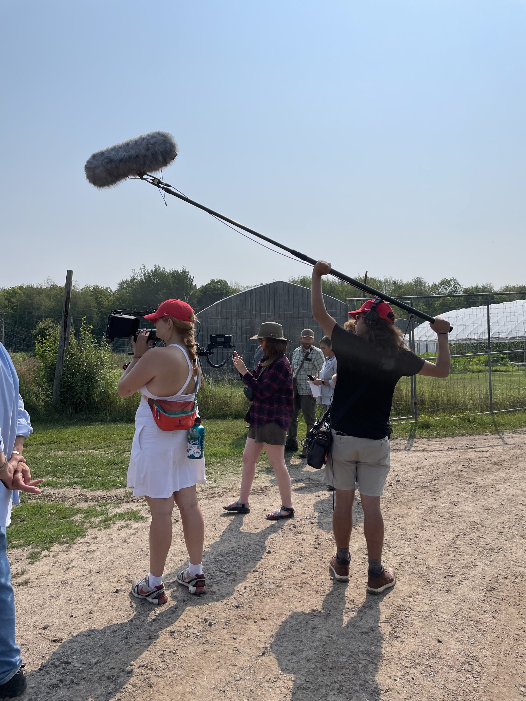 Videographers recording video and audio at a farm.